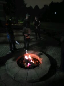 picture of two people behind a firepit