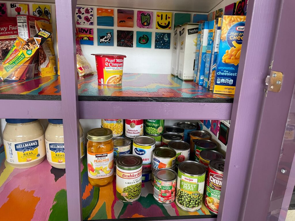 Micro Pantry inside view with food and small paintings made by kids