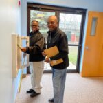 Two men checking a fire extinguisher