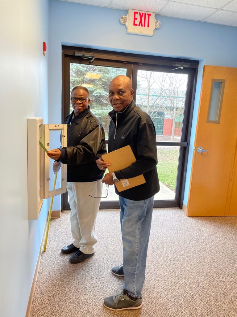 Two men checking a fire extinguisher