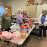 Women creating food baskets for distribution