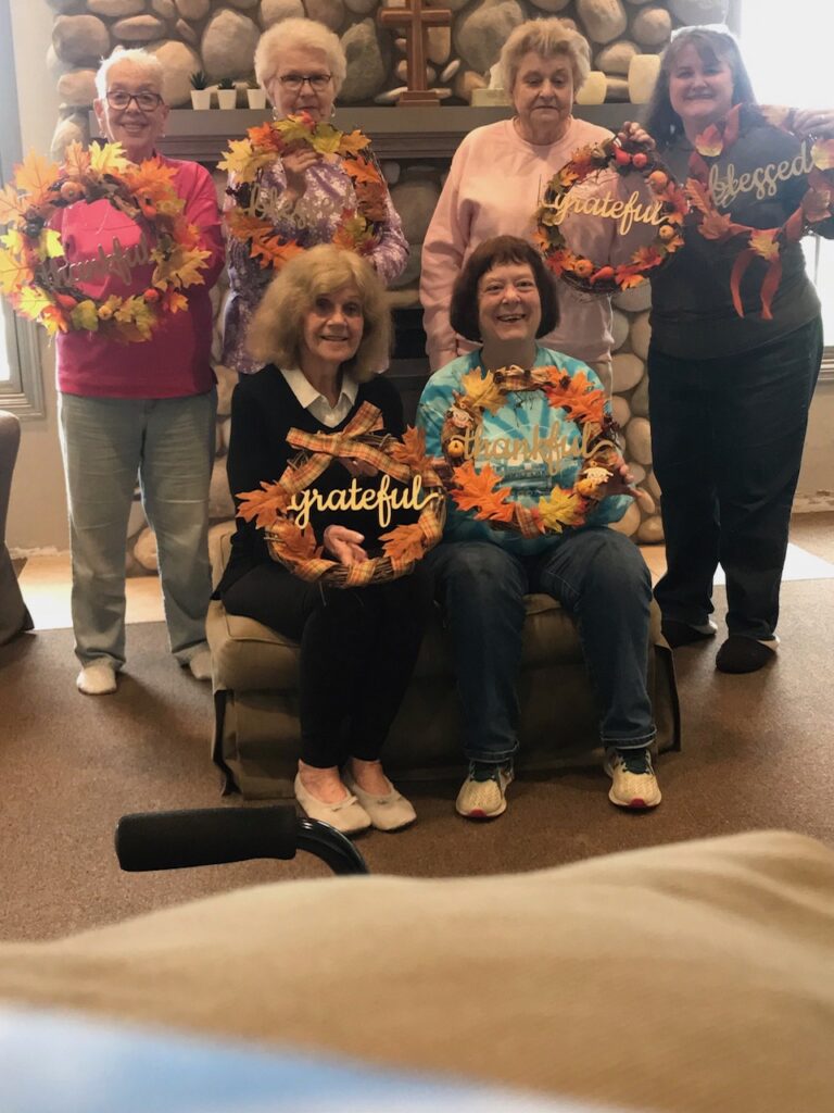 Women's Group holding "Grateful" weaths