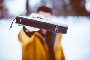 Bible in hand taken by ben-white--unsplash