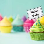 Colorful cupcakes and a sign that says Bake Sale, fair use