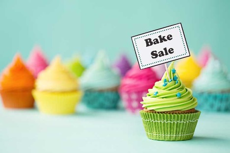Colorful cupcakes and a sign that says Bake Sale, fair use